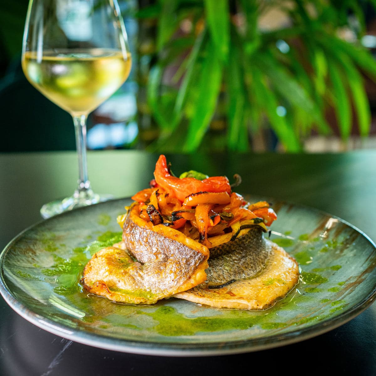 Lubina al horno con verduras y una copa de vino blanco